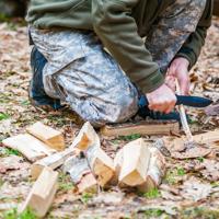 Man carving wood for campfire